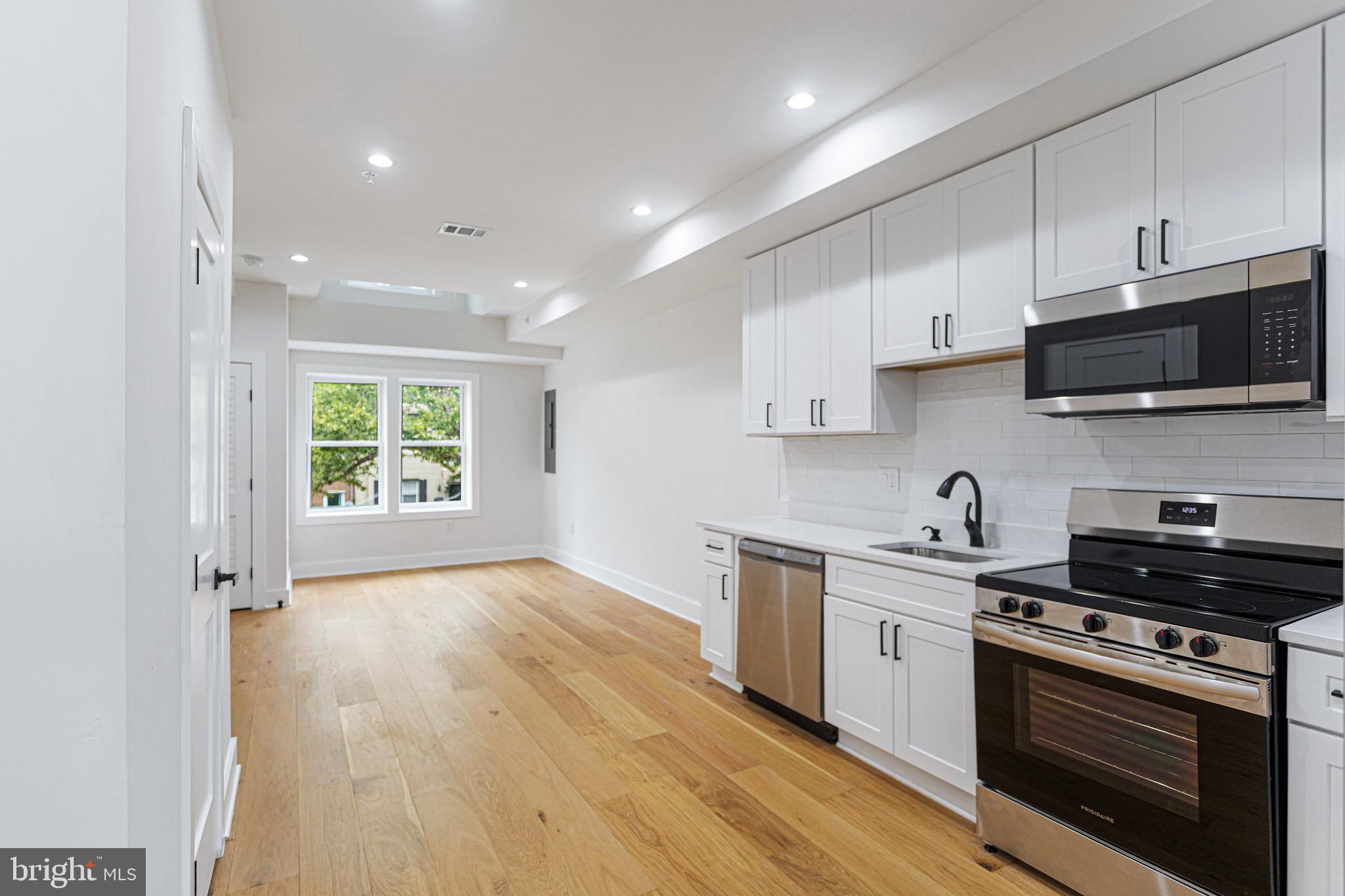 1107 Queen Street Northeast, Unit PH4 Washington, DC 20002 - Photo 4 of 28 a kitchen with stainless steel appliances a stove sink and cabinets