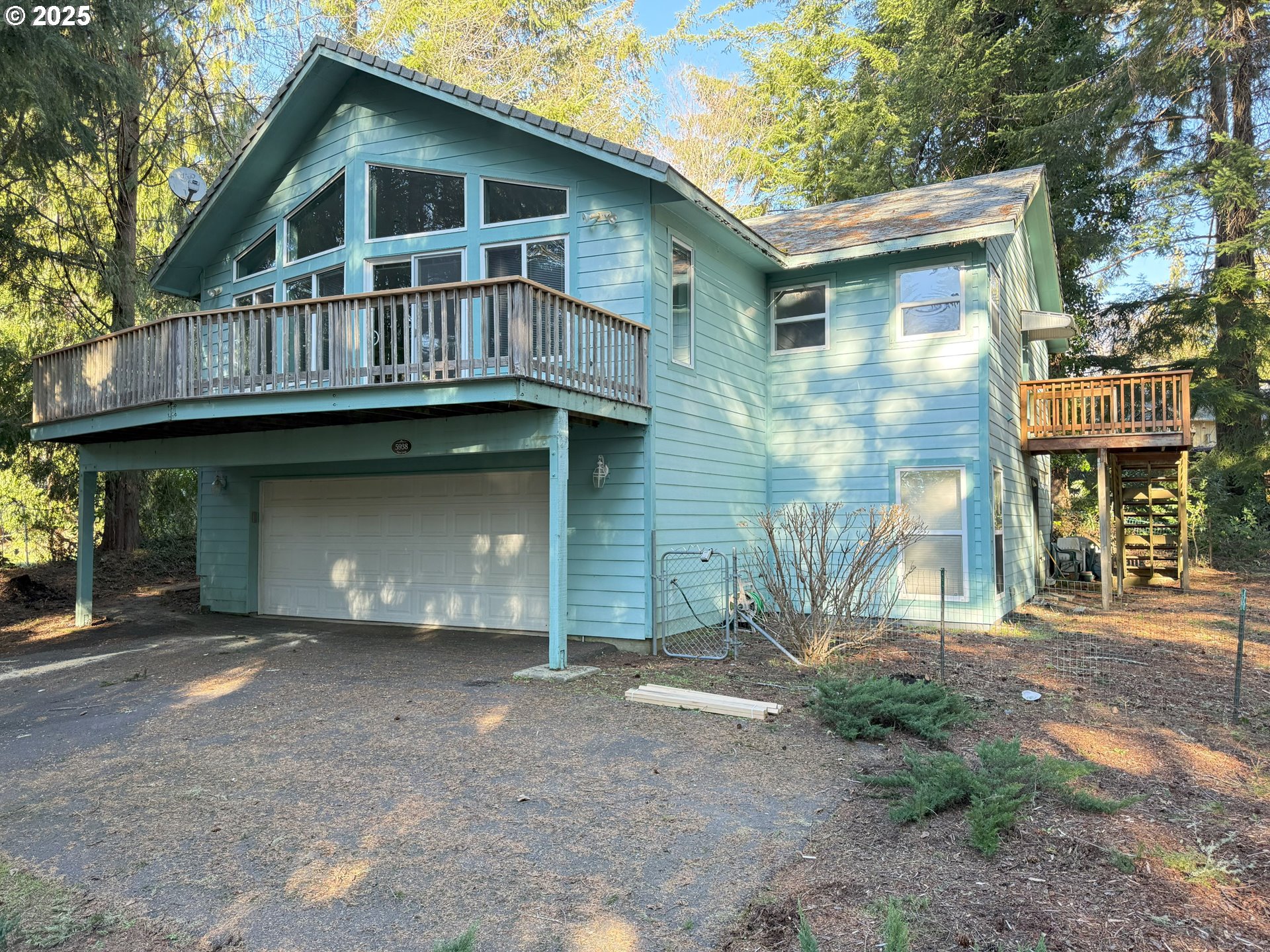 5938 View Loop Florence, OR 97439 - Photo 5 of 42 a front view of a house with glass windows and garage
