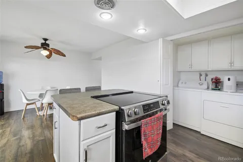 a kitchen with a stove cabinets and wooden floor