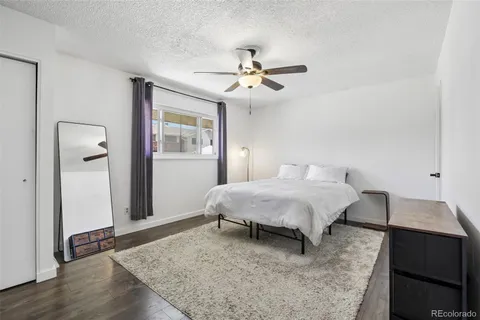 a spacious bedroom with a bed and wooden floor