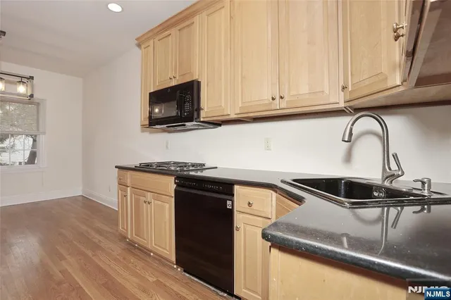 a kitchen with granite countertop a sink stainless steel appliances and cabinets