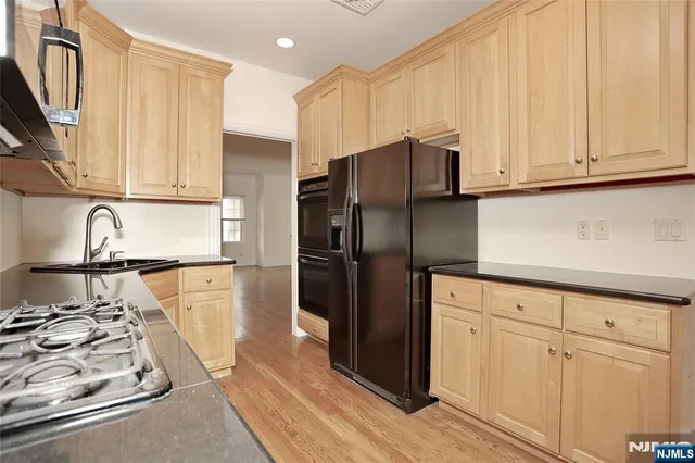 a kitchen with stainless steel appliances granite countertop a refrigerator and a stove