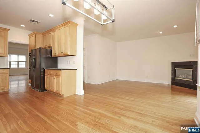 a view of kitchen with stainless steel appliances a refrigerator and wooden floor