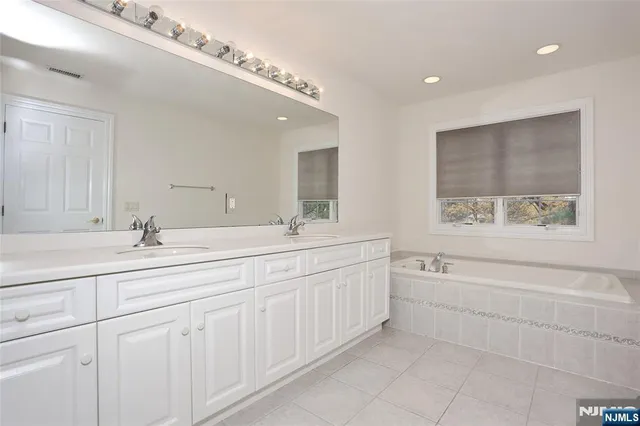a bathroom with double sink and a bathtub