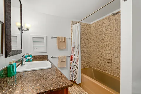 a bathroom with a granite countertop sink a toilet and a mirror