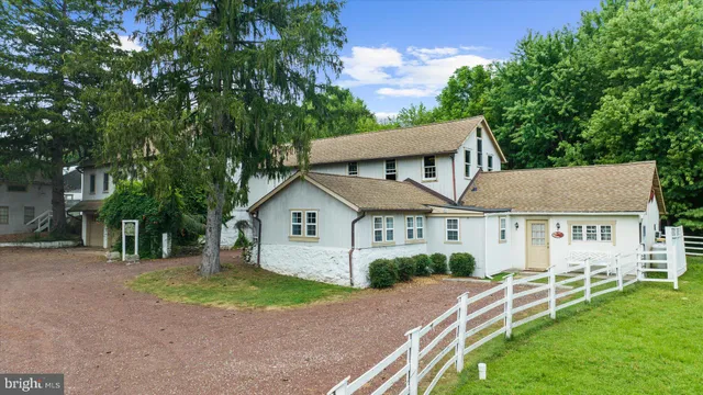 a view of a house with a yard and large tree