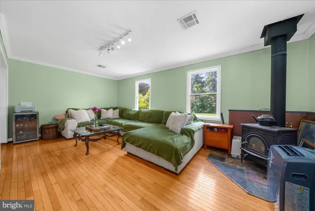a bedroom with a bed dresser and a large window