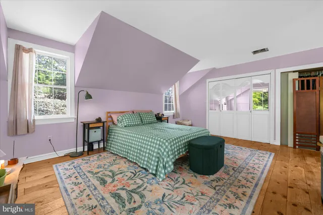 a bedroom with a bed and a large window