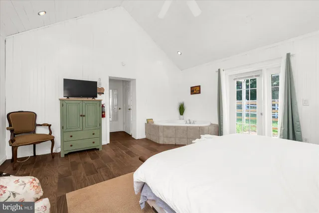 a spacious bedroom with a large bed and wooden floor