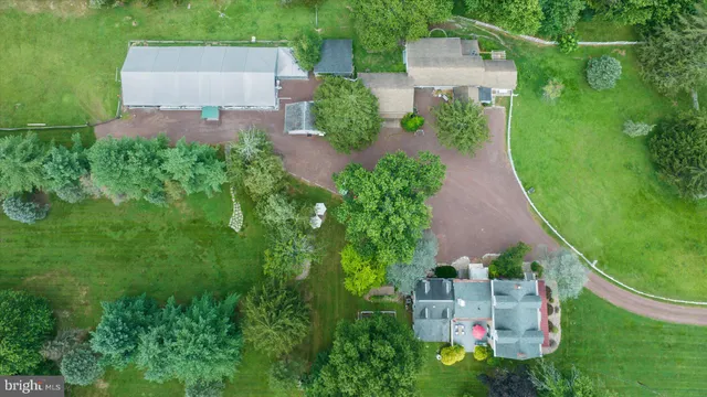 an aerial view of residential houses with outdoor space and trees