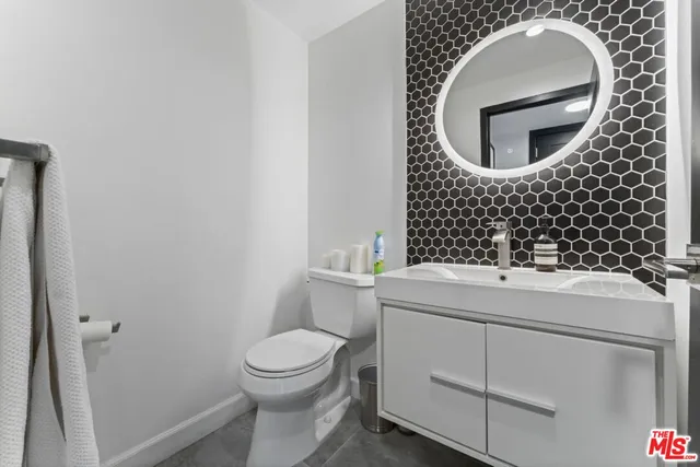 a bathroom with a sink mirror vanity and toilet