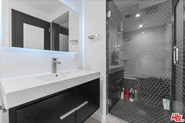 a bathroom with a sink shower and a mirror