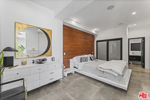 a bedroom with a large bed and a mirror