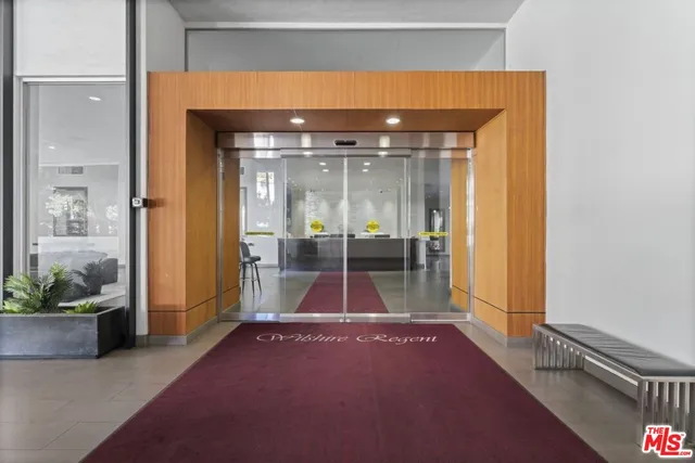 a view of a hallway with wooden floor and a living room