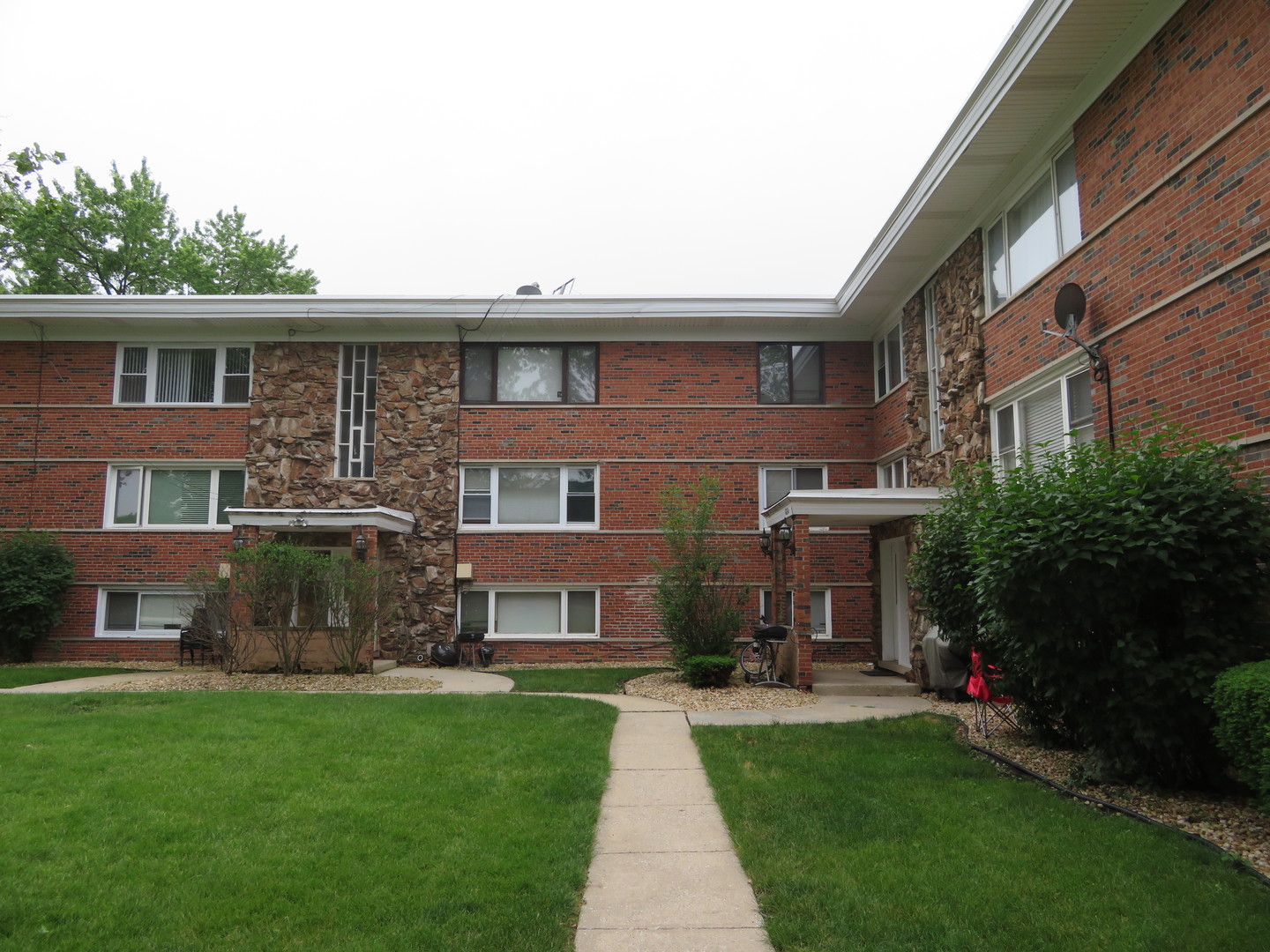 a front view of a brick house with a yard