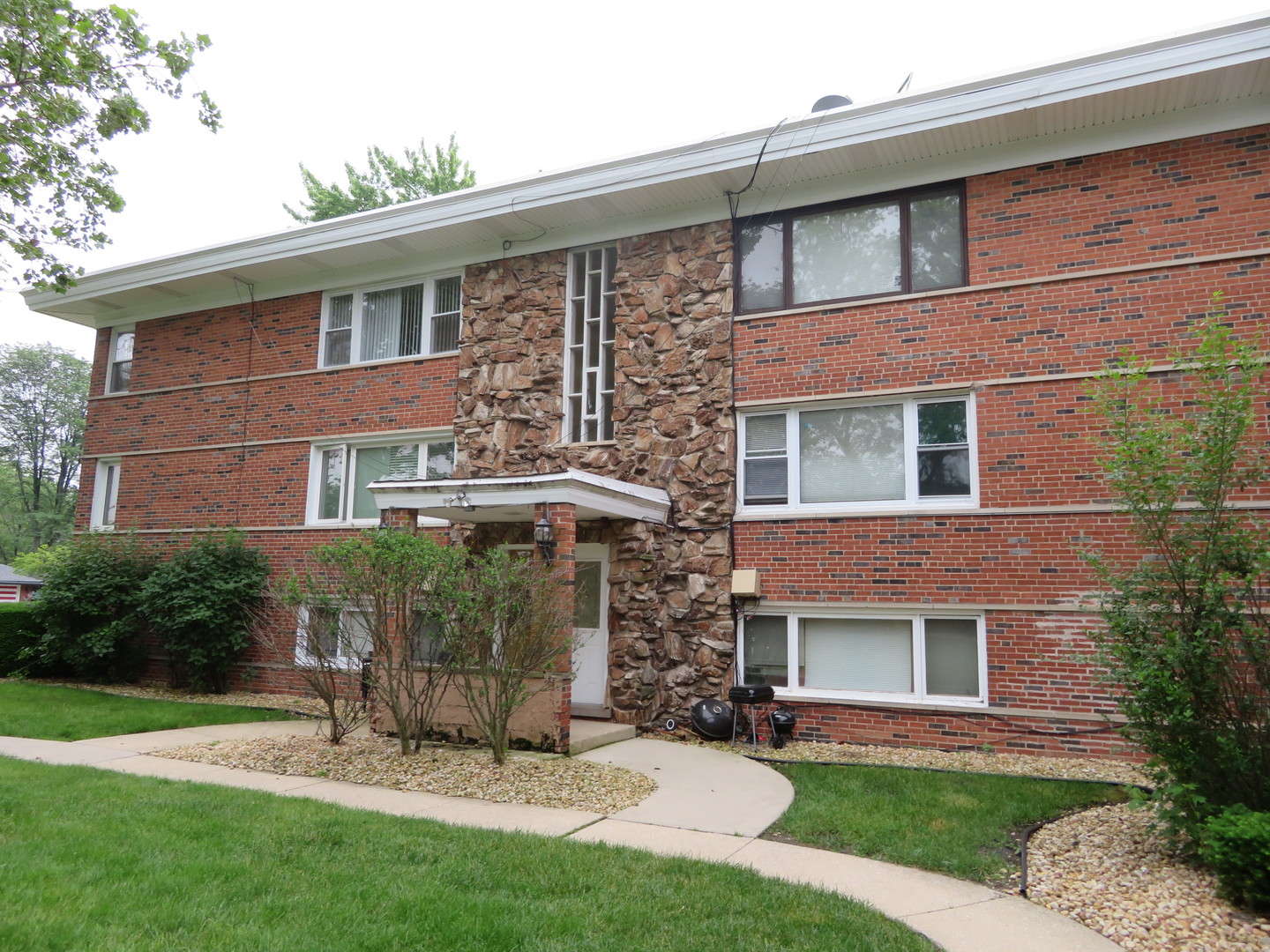 6834 West Lode Drive, Unit 3A Worth, IL 60482 - Photo 11 of 11 a view of a brick house with a yard and plants