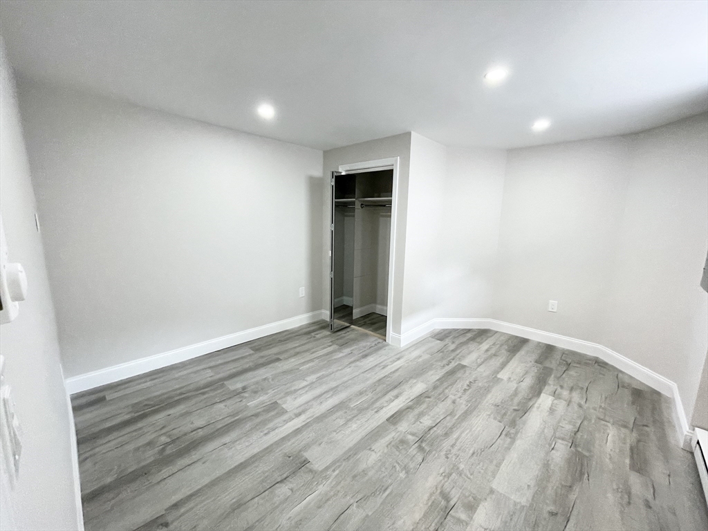 2 Holden Street, Unit 2 Boston, MA 02125 - Photo 6 of 12 an empty room with wooden floor and windows