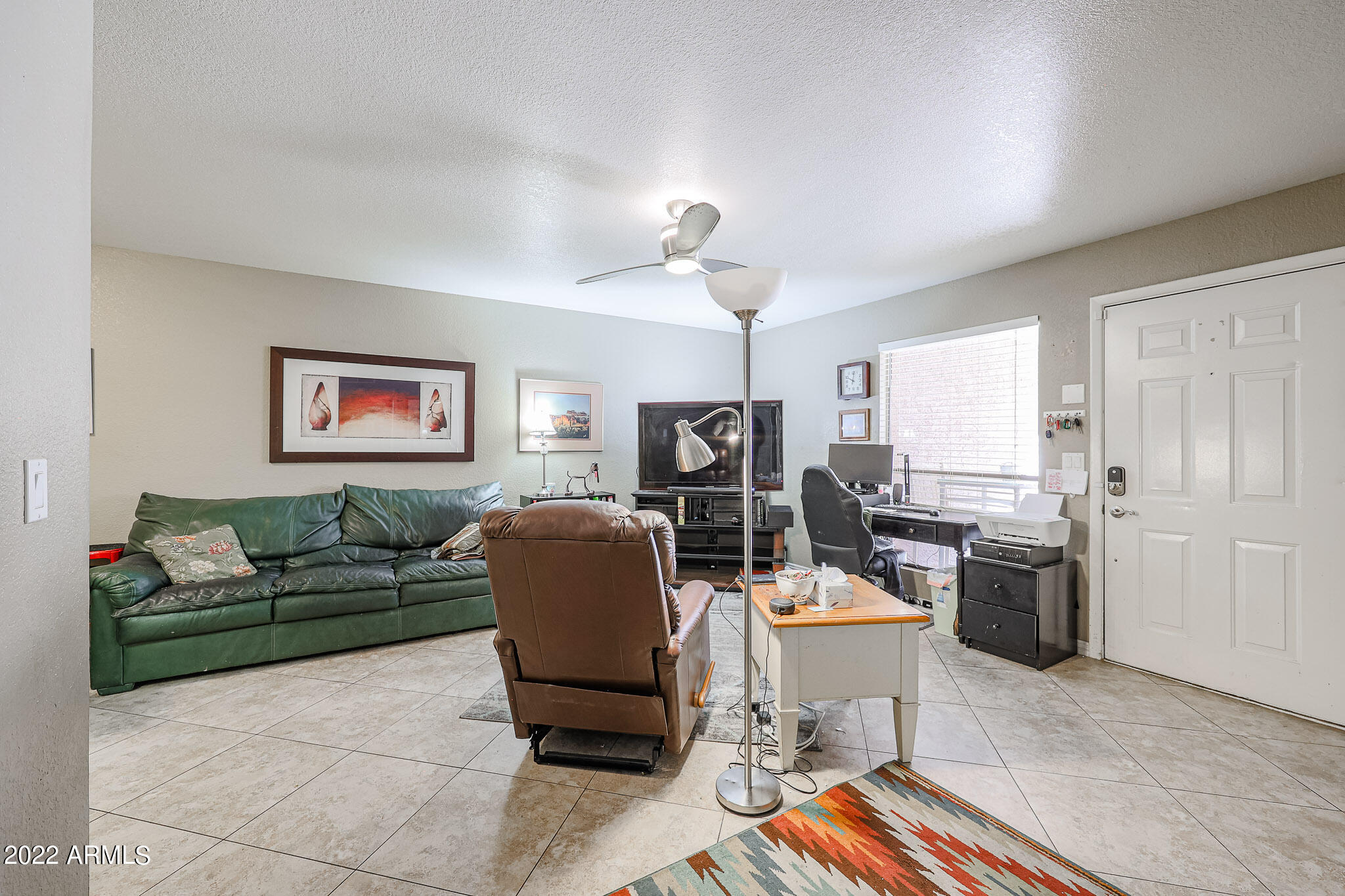 1340 North Recker Road, Unit 141 Mesa, AZ 85205 - Photo 7 of 17 a living room with furniture a rug and kitchen view