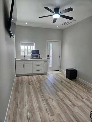 a large kitchen with hardwood floor a sink stainless steel appliances and cabinets