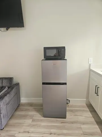 a utility room with wooden floor washer and dryer