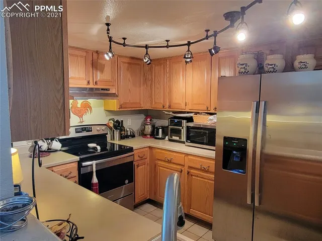 a kitchen with stainless steel appliances granite countertop a refrigerator a sink and a stove