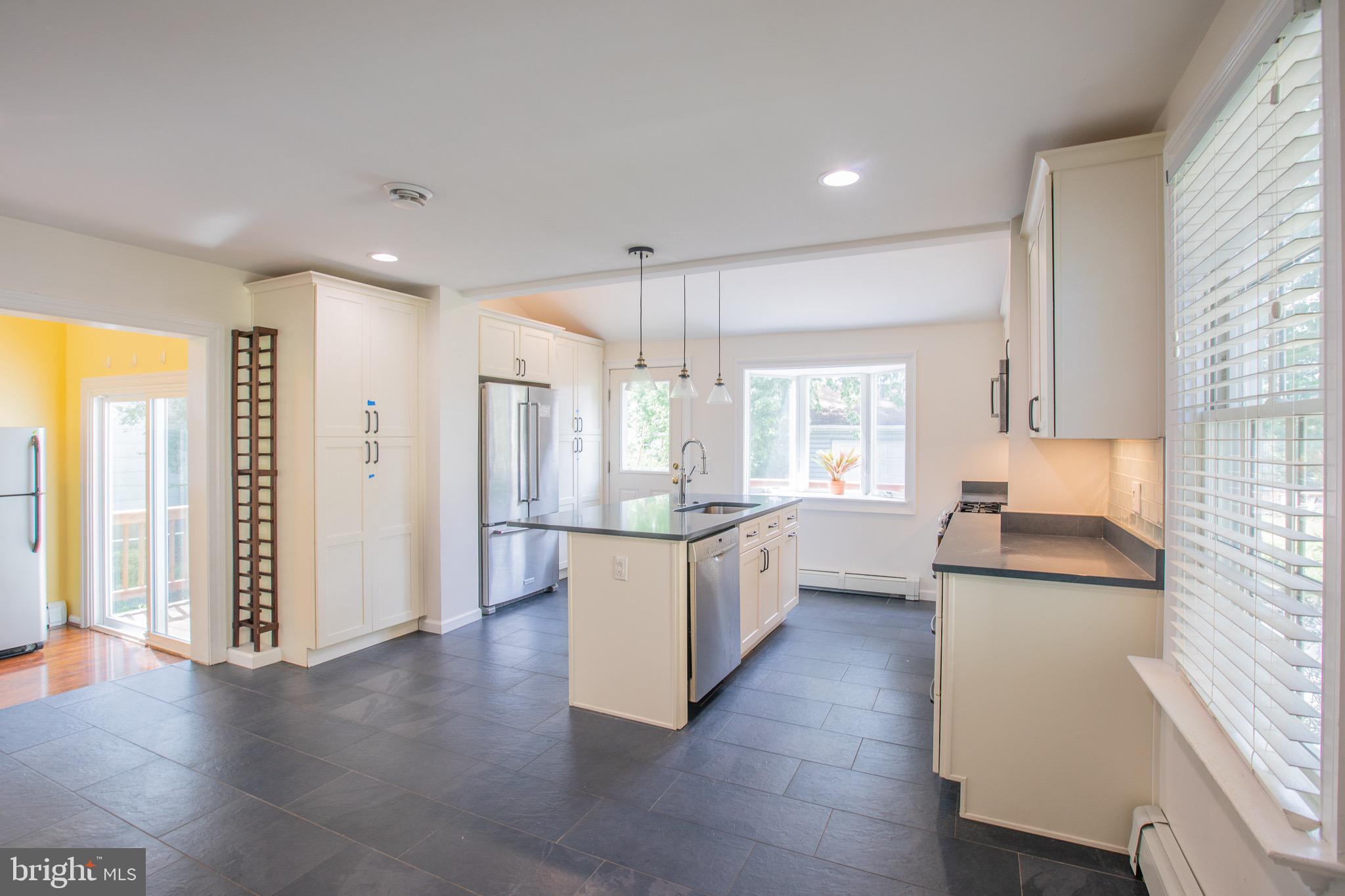 8875 Baltimore Street Savage, MD 20763 - Photo 11 of 32 a kitchen with stainless steel appliances granite countertop a refrigerator a sink dishwasher a stove and white countertops with wooden floor