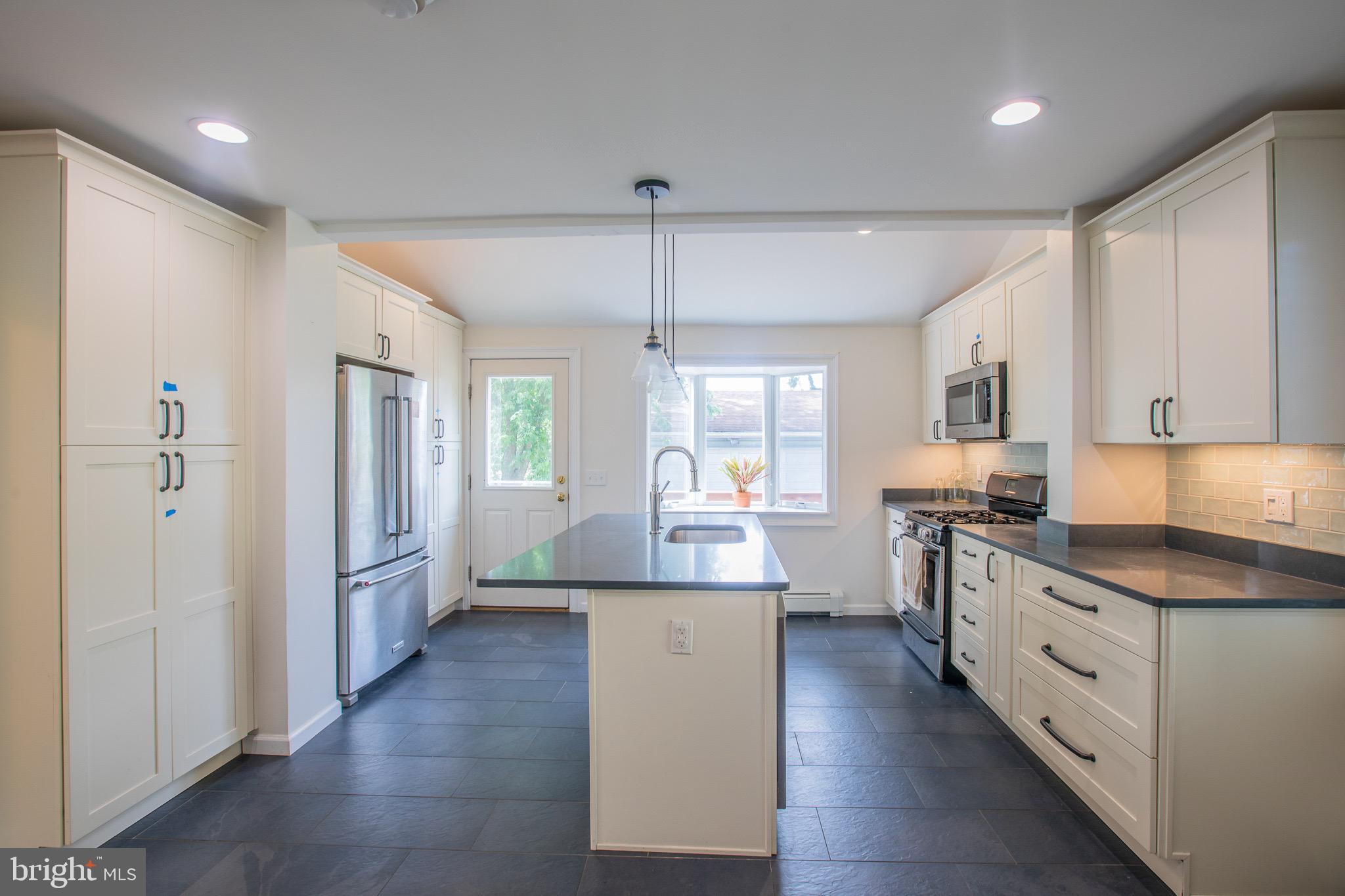 8875 Baltimore Street Savage, MD 20763 - Photo 12 of 32 a kitchen with refrigerator and cabinets