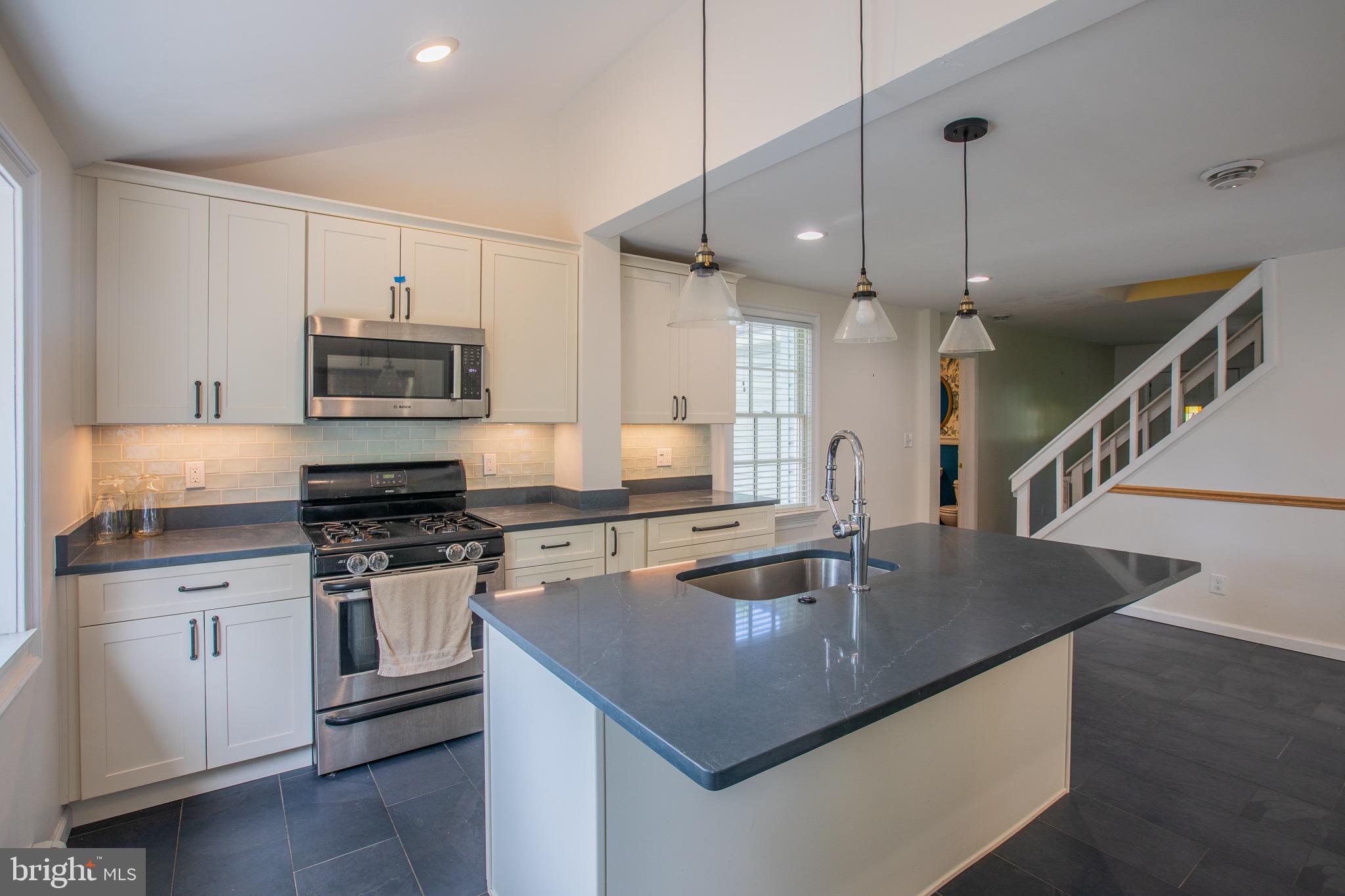 8875 Baltimore Street Savage, MD 20763 - Photo 13 of 32 a kitchen with stainless steel appliances granite countertop a sink a stove and a wooden floors