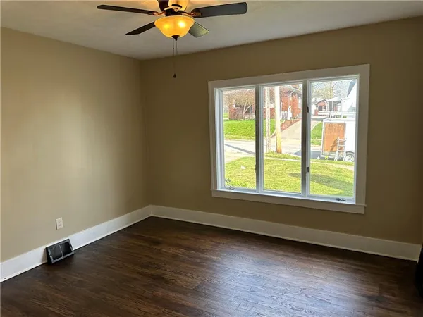 a view of a room with wooden floor and a window