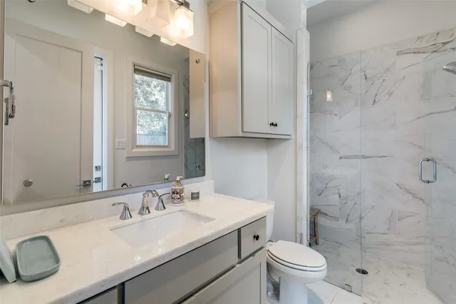 a bathroom with a sink toilet vanity and shower