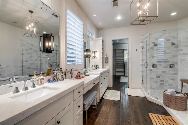 a bathroom with a granite countertop sink a toilet a mirror and shower