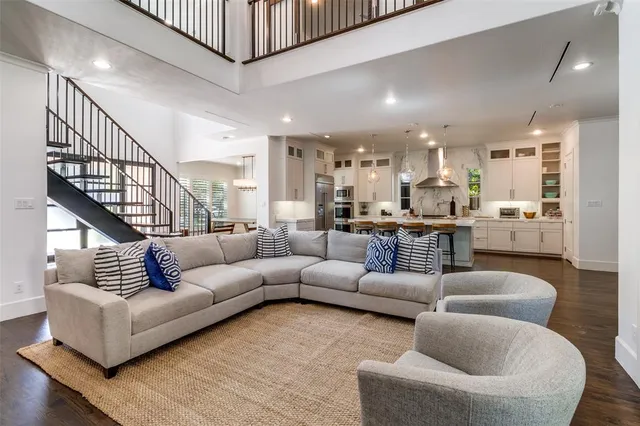 a living room with furniture kitchen view and a wooden floor