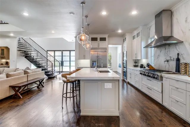 a kitchen with stainless steel appliances granite countertop a lot of counter space and a wooden floors