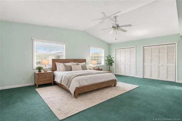 a spacious bedroom with a bed chandelier and a window