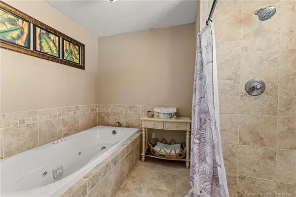 a bathroom with a tub a sink and a shower