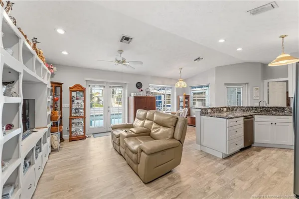 a living room with stainless steel appliances granite countertop furniture and a kitchen view