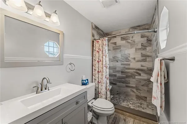 a bathroom with a sink toilet a mirror and shower