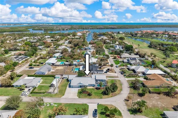 an aerial view of residential houses with outdoor space and ocean view