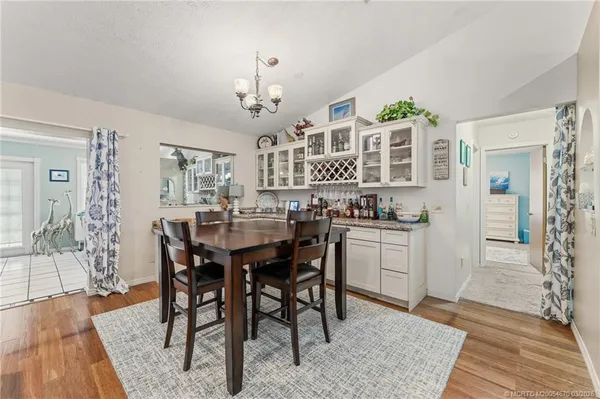 a kitchen with a dining table chairs and white cabinets