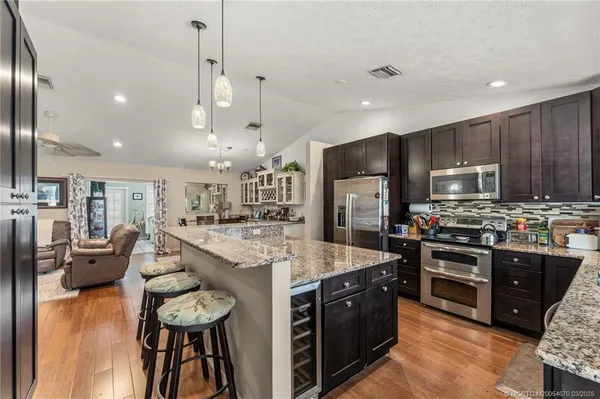 a large kitchen with stainless steel appliances lots of counter space and wooden floor