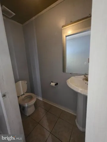 a bathroom with a granite countertop toilet and a sink