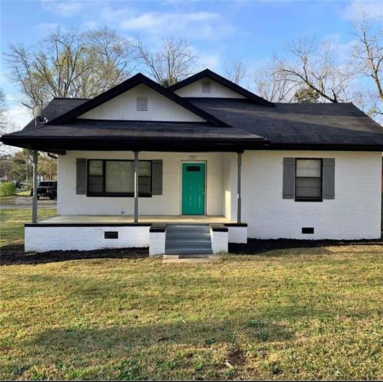 a view of a house with a large window and a yard