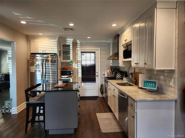 a kitchen with kitchen island granite countertop a sink counter top space and stainless steel appliances