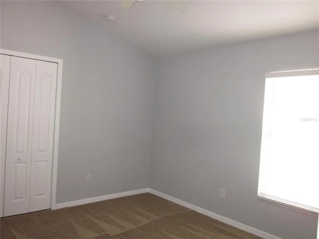 a view of a small space with wooden floor and a window