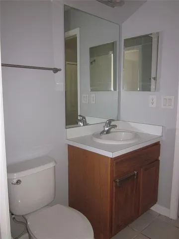 a bathroom with a granite countertop sink a toilet and a mirror