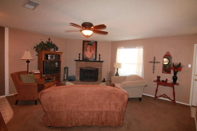 2525 110th Street Lubbock, TX 79423 - Photo 2 of 10 a bed room with furniture and a fireplace
