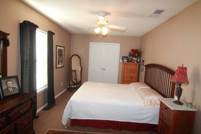 2525 110th Street Lubbock, TX 79423 - Photo 8 of 10 a bedroom with a bed and a flat tv screen on dresser