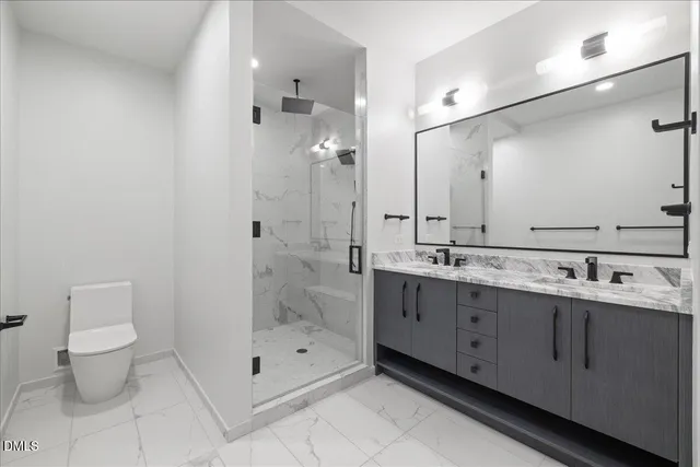 a bathroom with a double vanity sink mirror and toilet