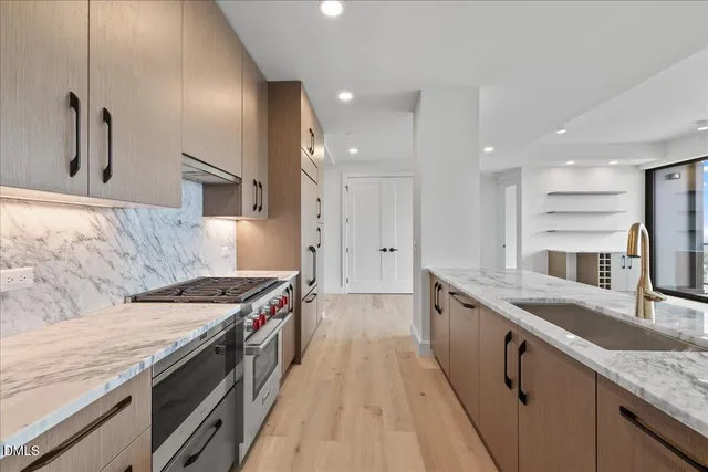 a kitchen with stainless steel appliances granite countertop a sink stove and refrigerator