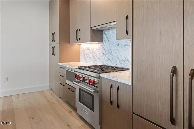 a kitchen with a stove and a wooden floor